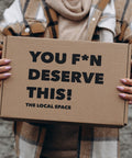The Local Space gift box with a card that says You F*n Deserve This