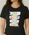 Person wearing a black t-shirt with 'The Good Old Days' text design.